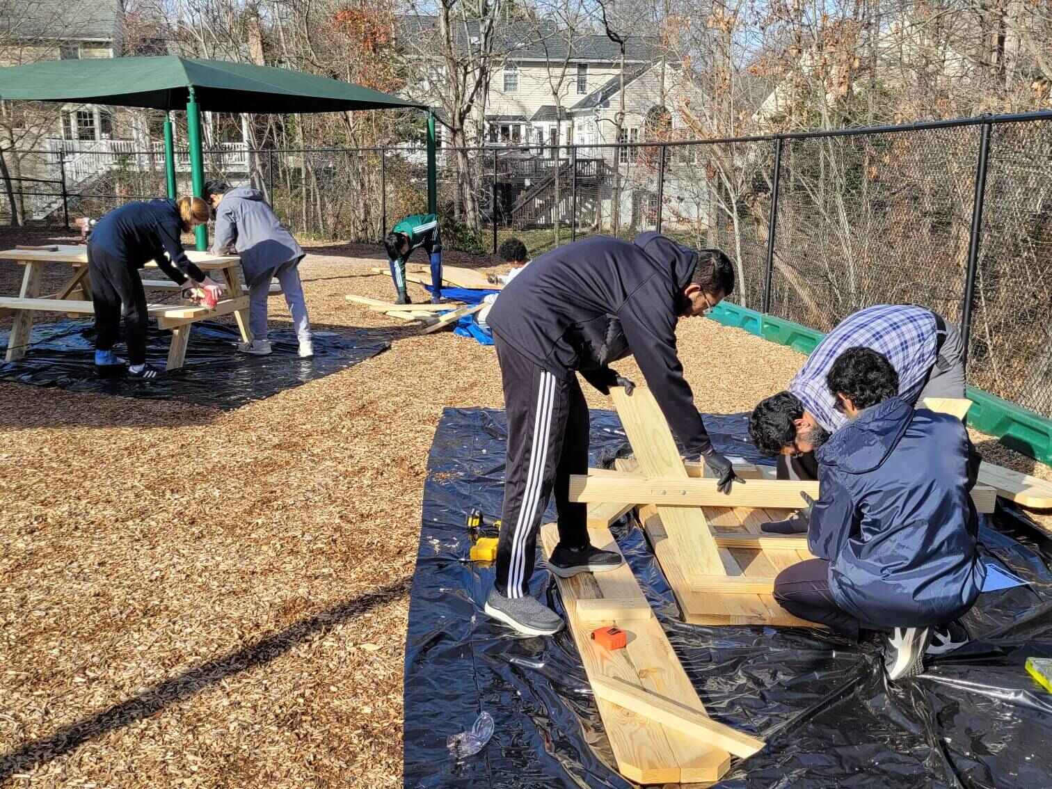 Volunteers attaching benches to the second table